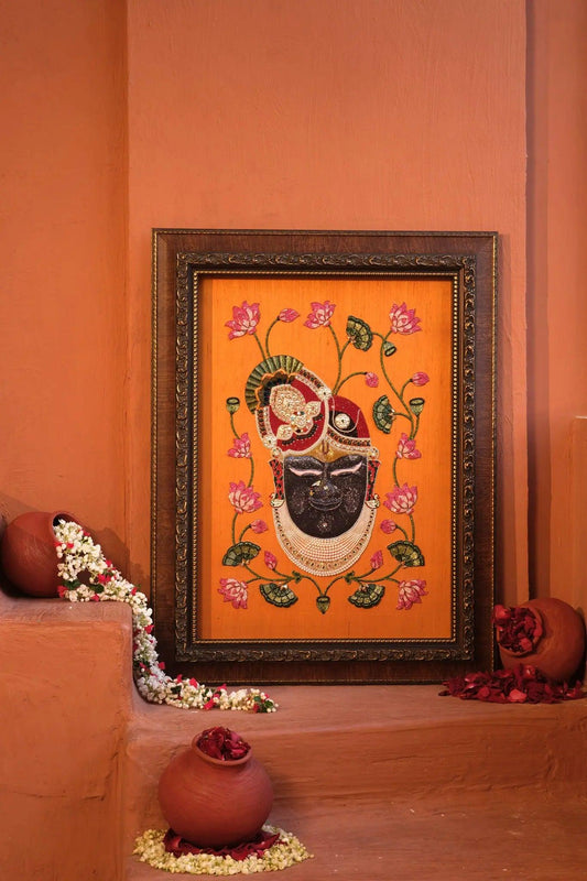 Shrinathji Pichwai hand-embroidered art on orange silk with lotus motifs, luxury wall decor by Iragai