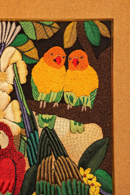 Embroidered panel with two yellow birds on a branch surrounded by leaves and flowers.