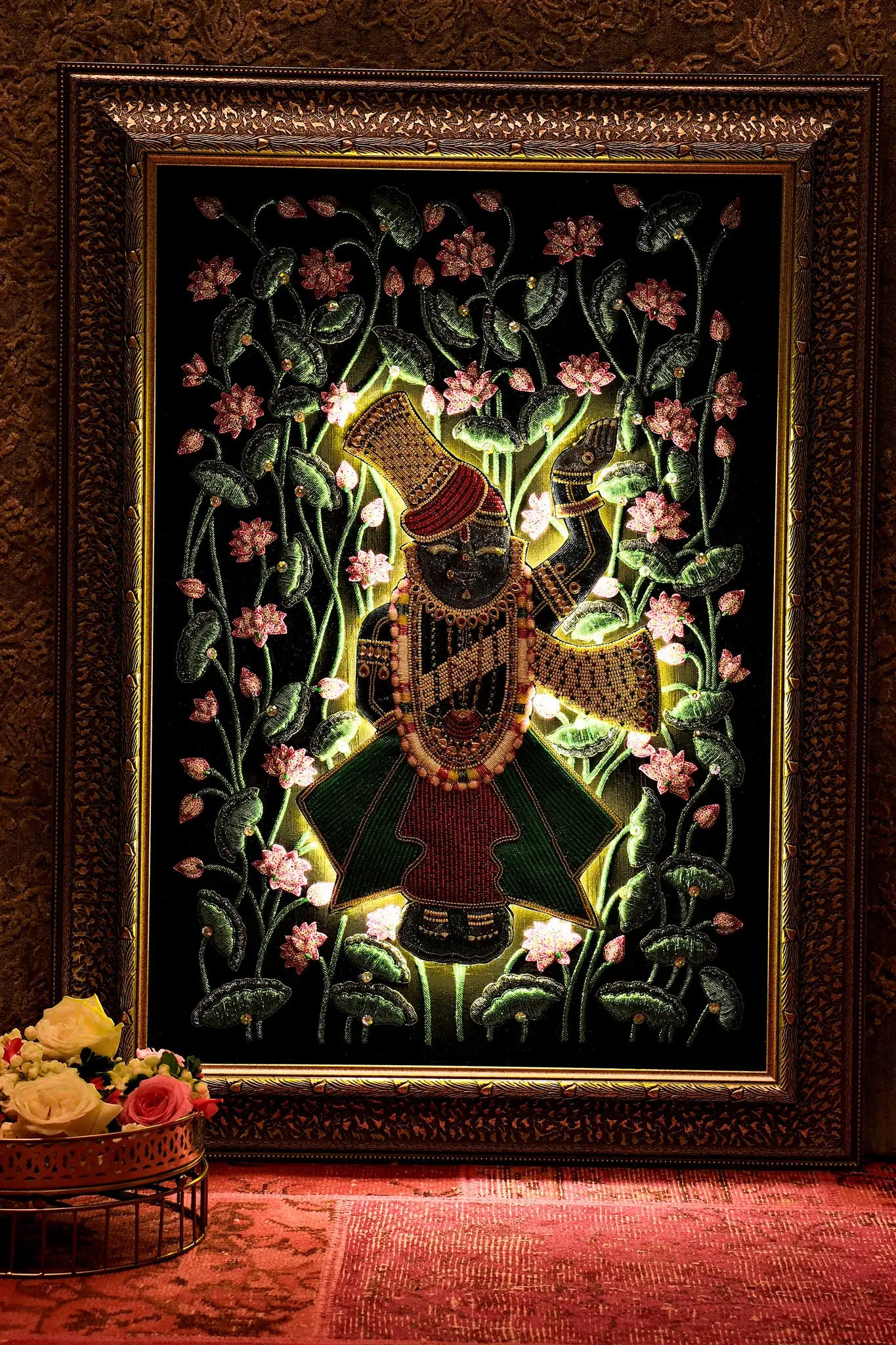 Decorative wall art with a character surrounded by flowers in a gold frame.