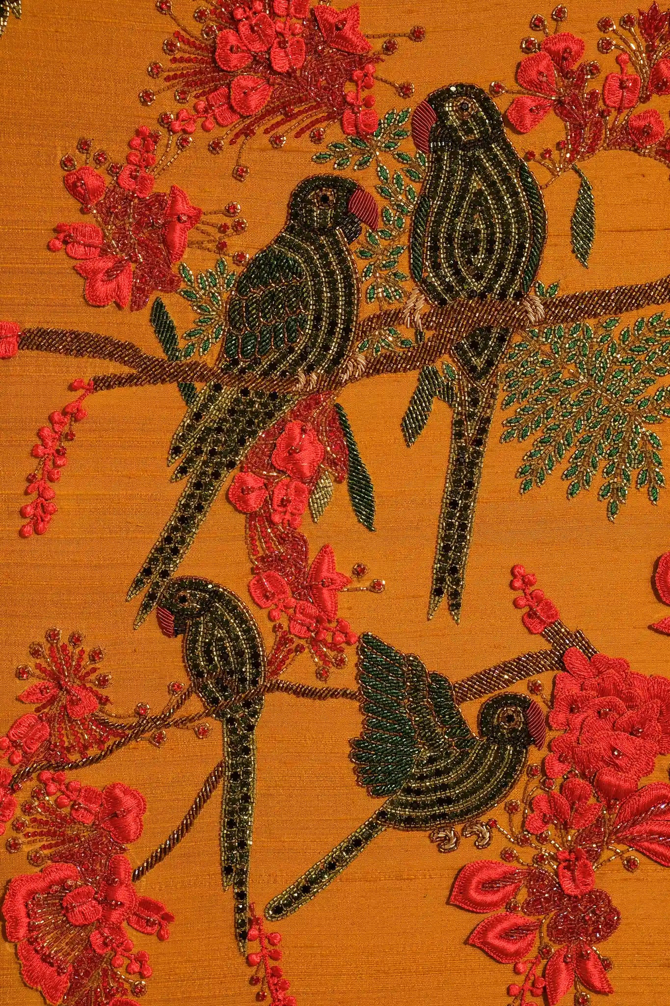 Decorative fabric with embroidered birds and flowers on a mustard yellow background