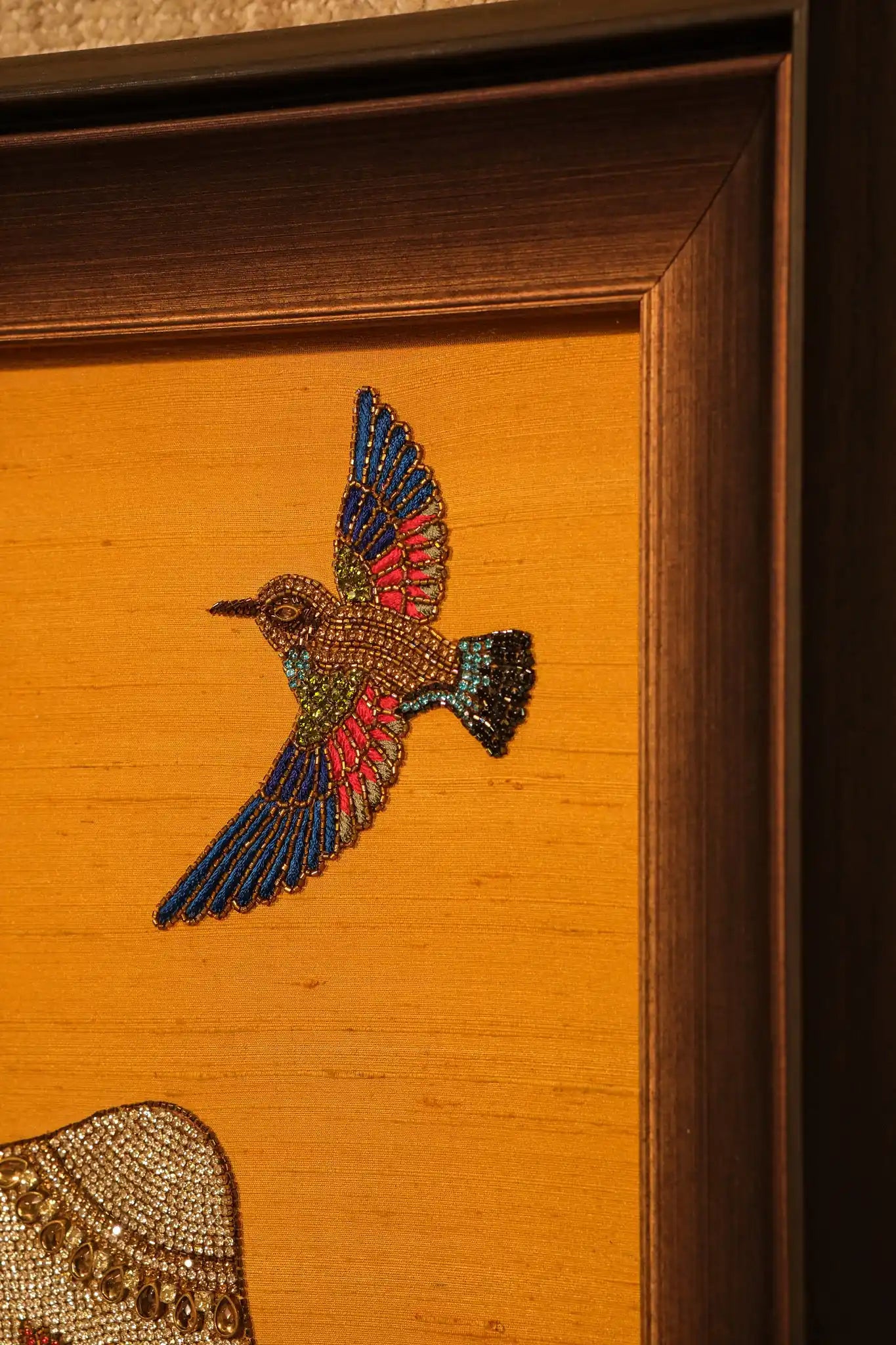 Embroidered bird design on a wooden surface